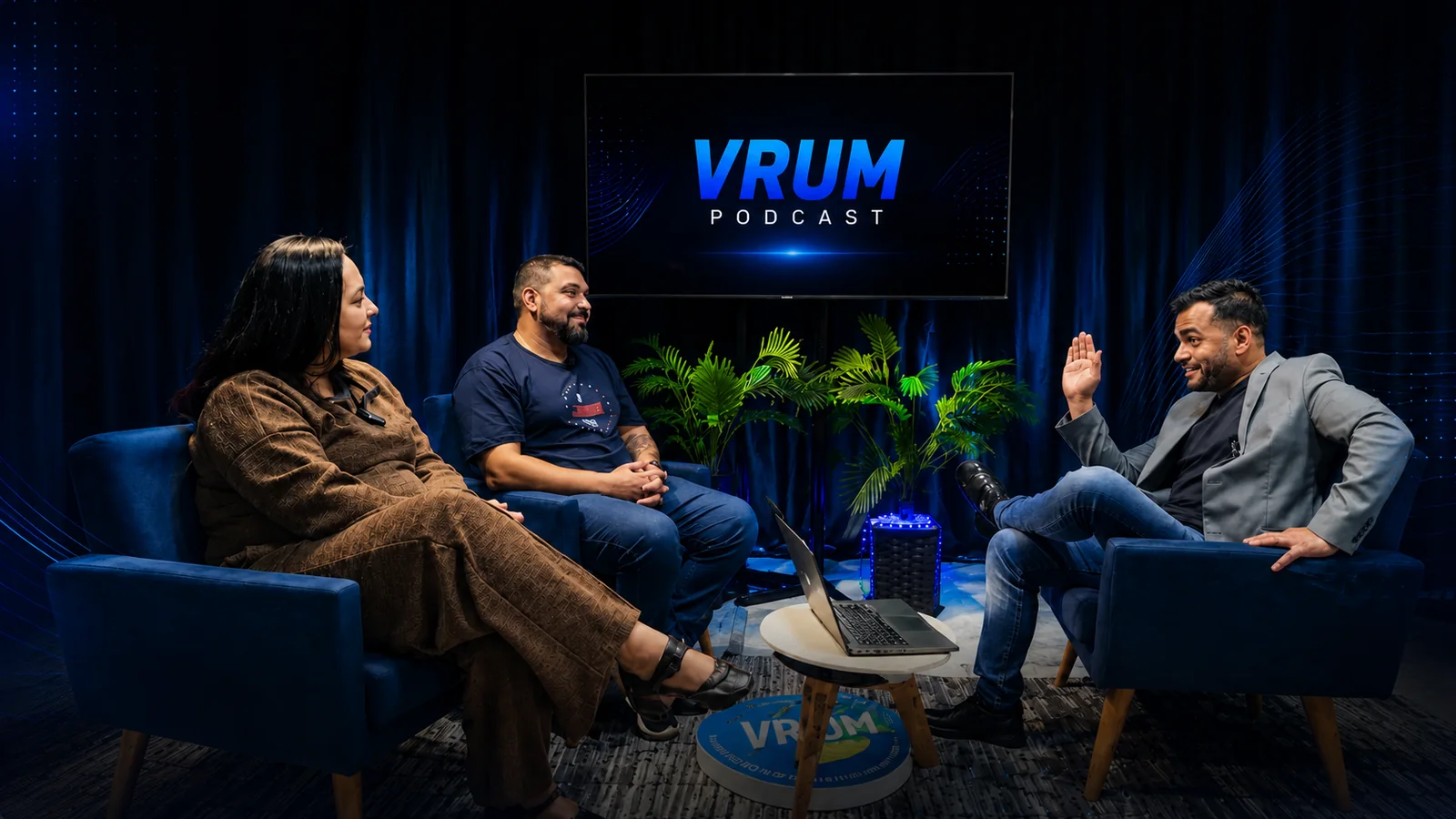 Gravação do VRUM Podcast: três pessoas conversando em poltronas azuis, com a tela do VRUM Podcast ao fundo